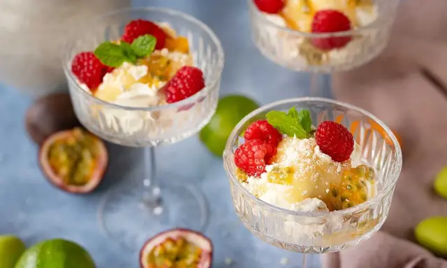En härlig påskdessert i glas med grädde, passionsfrukt, hallon och mynta. Perfekt för påskfirandet!