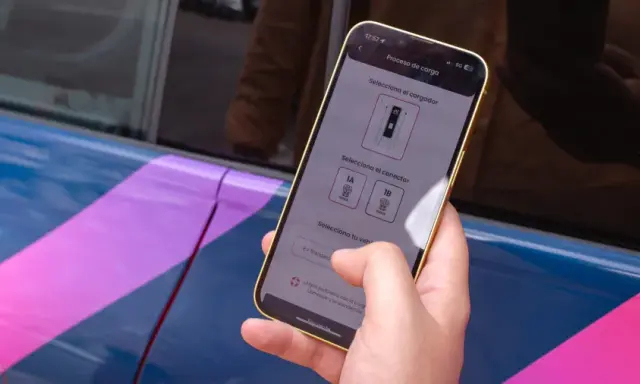 Mano usa el móvil para seleccionar el conector de carga en la mejor app cargadores eléctricos.