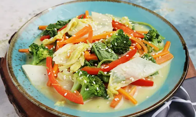Buntes Gemüsegericht mit Chinakohl, Karotten, Brokkoli und Paprika in cremiger Sauce, bestreut mit Sesam. Leckere Chinakohl Rezepte!