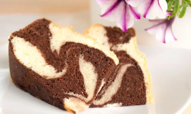 Zwei Stücke saftiger Marmorkuchen mit schöner Maserung, perfekt für ein gemütliches Kaffeetrinken. Dieses Marmorkuchen Rezept ist ein Klassiker.