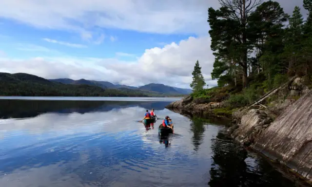 Zwei Kanus auf dem Loch Ness, umgeben von schottischen Highlands. Vielleicht sucht Nessie nach Gesellschaft?