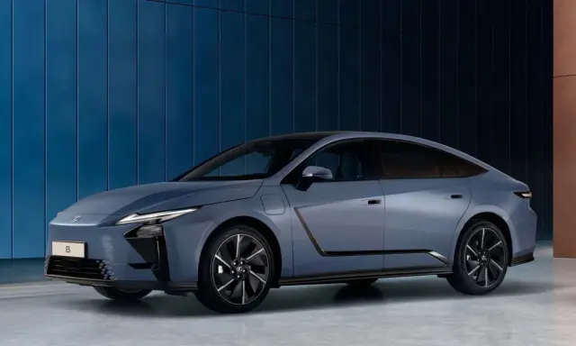 El elegante Lexus ES 2026, un sedán azul metálico, se exhibe contra una pared azul texturizada.