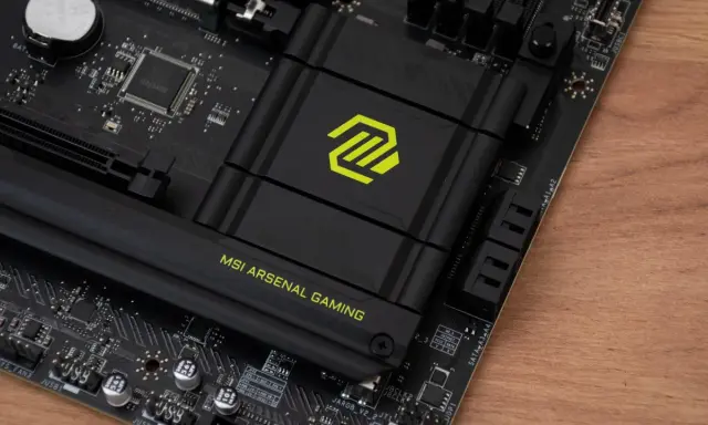 Płyta główna MSI z logo "MSI ARSENAL GAMING". Widoczny radiator z zielonym symbolem, a pod nim znajduje się chipset.