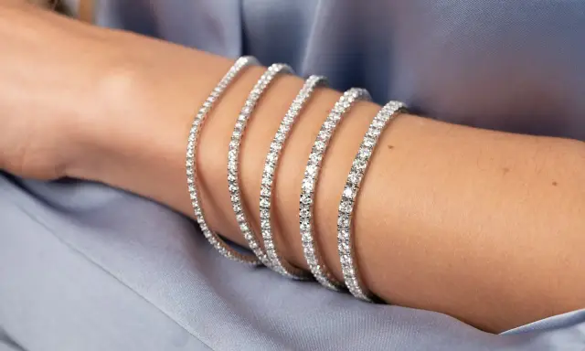 Bracciale tennis, un gioiello scintillante che ricorda la linea di un campo da gioco, indossato su un braccio.
