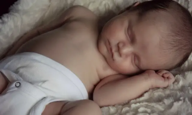 Słodki noworodek śpi spokojnie, jak wiele drzemek roczne dziecko. Otulony w miękkie futerko, wygląda na bardzo zrelaksowanego.