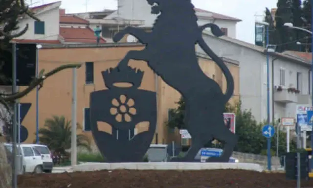 Leone rampante con stemma floreale, simbolo di Santa Margherita di Belice, domina la piazza.
