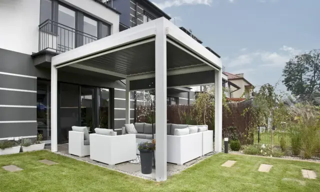 Une pergola moderne avec salon de jardin, offrant un espace extérieur confortable. C'est une définition pratique de pergola.