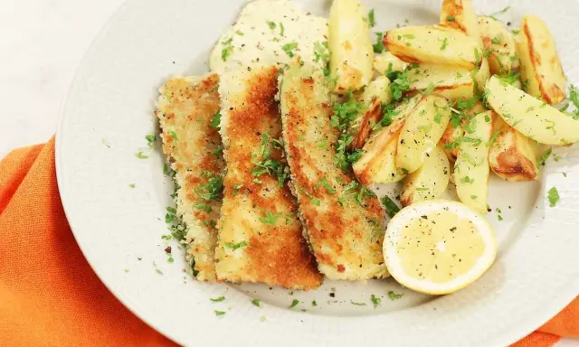 Krispigt friterad zucchini med pommes frites, en klick sås och en citronskiva.