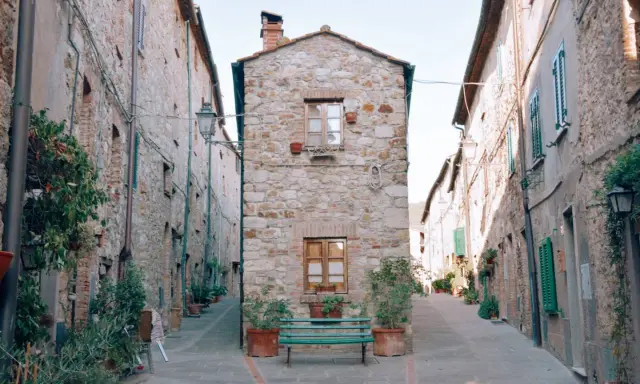Un vicolo stretto con case in pietra e piante in vaso. Un invito a scoprire cosa vedere a Cecina, tra scorci pittoreschi e storia.