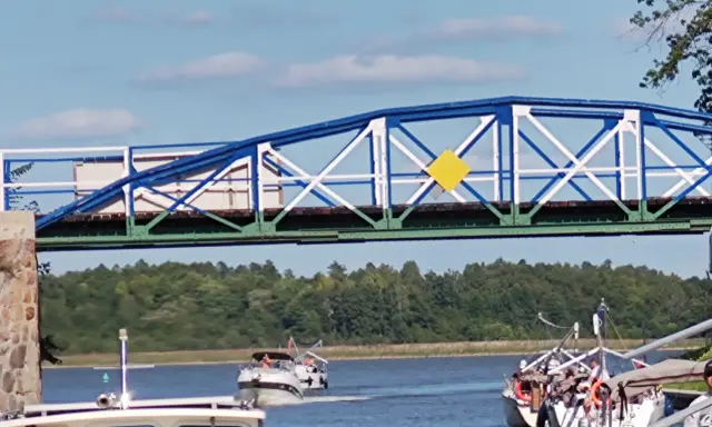 Żółty romb na niebiesko-białym moście to jeden z znaków kardynalnych na wodzie, wskazujący drogę wodną.