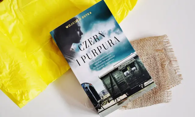 Okładka książki "Czern i Purpura" z pociągiem i sylwetką kobiety.