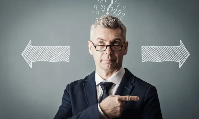 Un homme d'affaires réfléchit, entouré de points d'interrogation et de flèches. Il cherche la meilleure solution, peut-être avec un logiciel GED.