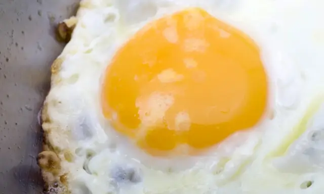 Jajko sadzone na patelni, z apetycznym, żółtym żółtkiem. Zastanawiasz się, ile kcal ma jajko sadzone?