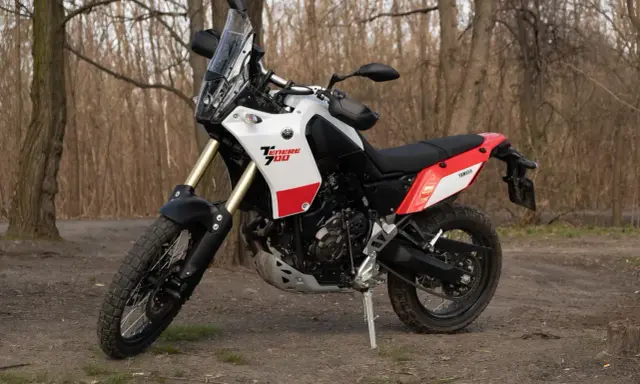 Yamaha Tenere 700 waga idealna na wyprawy. Motocykl stoi na leśnej ścieżce, gotowy do przygody.
