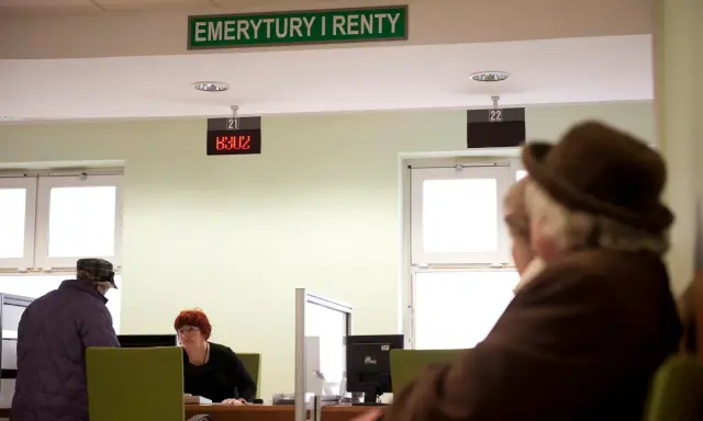 Ludzie czekają na obsługę w urzędzie "Emerytury i Renty". Zastanawiają się, w jakim miesiącu najlepiej przejść na emeryturę.