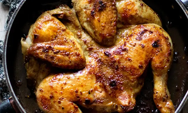 Pollo alla diavola succulento e dorato, cotto in padella con spezie piccanti.