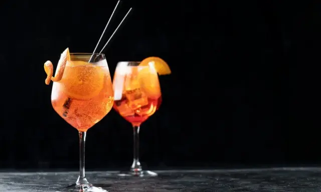 Zwei Aperol Spritz Gläser mit Orangenscheibe und Zitrusschale, perfekt für das Aperol Spritz Rezept in ml.