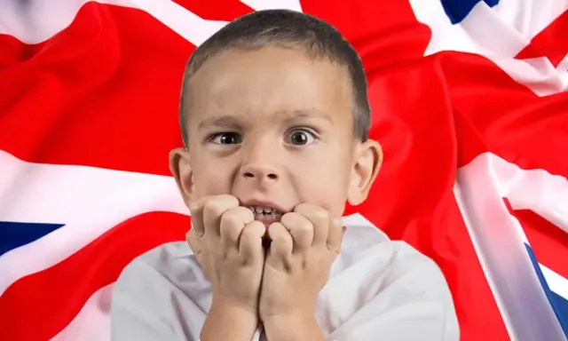 Przerażony chłopiec przed flagą Wielkiej Brytanii. Czy tak wygląda nauka jak nauczyć się mówić po angielsku?
