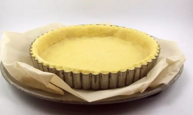 Pâte briochée prête à être cuite dans un moule à tarte. Idéal pour une recette de tarte sucrée ou salée.
