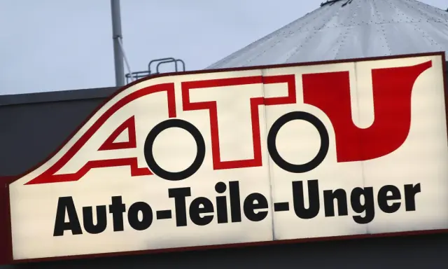 Leuchtreklame von A.T.U. Auto-Teile-Unger mit rotem Schriftzug und weißem Hintergrund.