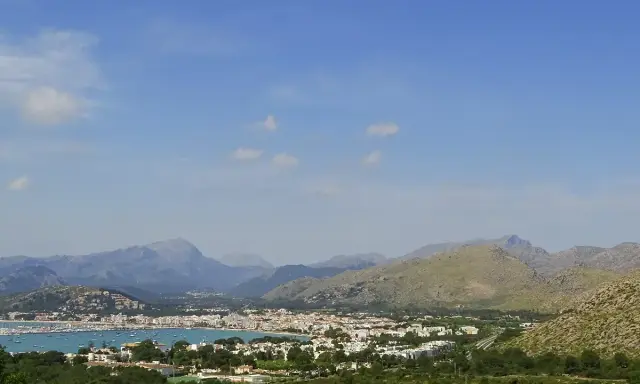 Vista panoramica del porto di Maiorca con montagne sullo sfondo e un mare pieno di barche.