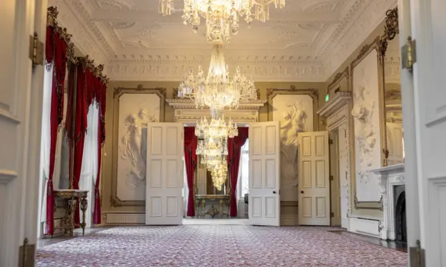 Ett elegant rum med kristallkronor och röda draperier i Dicksonska palatset.
