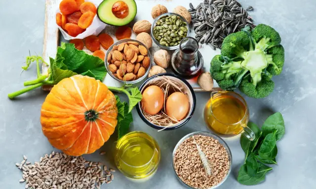 Vielfalt an vitamin e lebensmittel: Kürbis, Avocado, Mandeln, Sonnenblumenkerne, Brokkoli, Spinat, Eier und Öle.