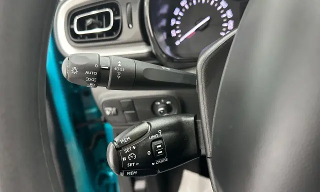 Palanca de luces con función AUTO y controles de crucero. Las luces adaptativas del coche se activan automáticamente.