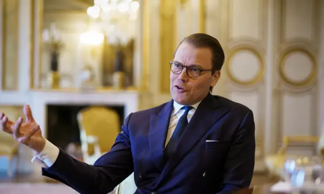 Prins Daniel i mörk kostym, med glasögon, gestikulerar. Rykten om prins Daniel otrogen sprids.