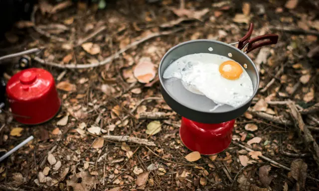 Stekt ägg i stekpanna på campingkök. Enkel och bra vandringsmat som ger energi för äventyret.