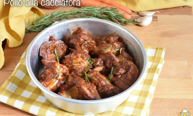 Succulento pollo alla cacciatora in padella, con rosmarino fresco e contorni di carote e aglio.