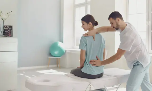Fizjoterapeuta bada plecy pacjentki. W takich sytuacjach, gdy choroba uniemożliwia pracę, można starać się o świadczenia, np. komu przysługuje renta chorobowa.