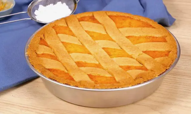 Pastiera napoletana ricetta originale: una torta dorata con decorazione a griglia, pronta per essere gustata.