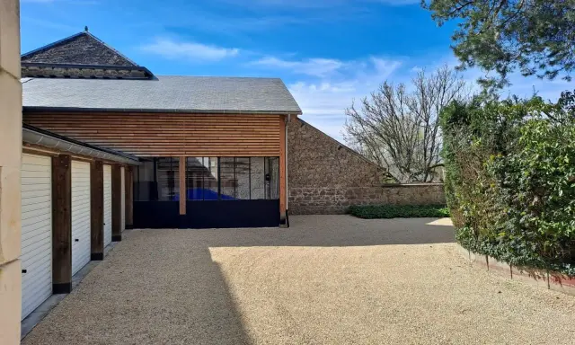 Belle maison tradi pierre Saint Junien avec garage, jardin et ciel bleu.