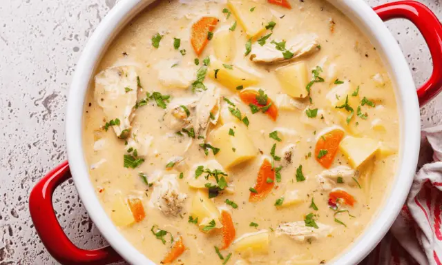 Cremige Hühnersuppe mit Kartoffeln und Karotten, ein Klassiker unter den Suppen Rezepten, garniert mit Petersilie.