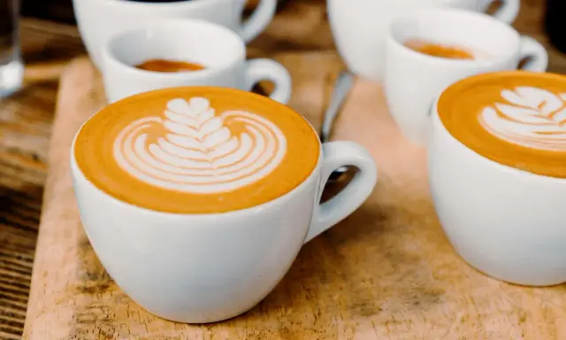 Kaffee-Kunst: Ein Cortado und ein Flat White, die sich in ihrer Zubereitung unterscheiden, aber beide mit Latte Art verziert sind.
