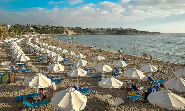 Piękna plaża na Cyprze, gdzie cypr pogoda w listopadzie pozwala na relaks pod białymi parasolami.