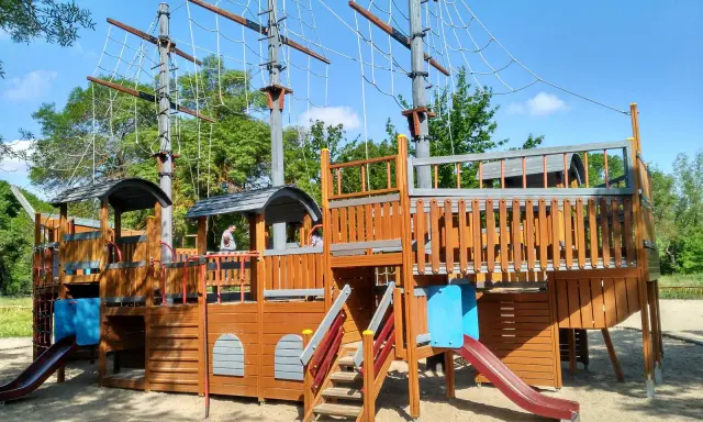 Un gran parque infantil con forma de barco pirata, ideal para aventuras en un parque infantil casa de campo.
