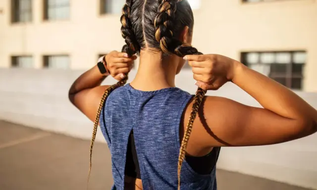 Frauen flechten Boxer Braids für ein sportliches Outfit.