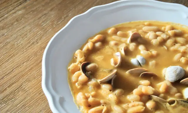 Plato de fabes con almejas, un guiso tradicional lleno de sabor y textura.