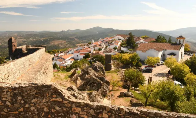 Blick auf das malerische Dorf Portalegre mit seinen weißen Häusern und roten Dächern, umgeben von einer alten Steinmauer und bergiger Landschaft.