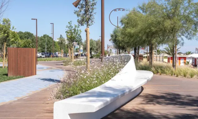 Passeggiata moderna con panchina bianca e fiori sulla bellariva di Rimini.
