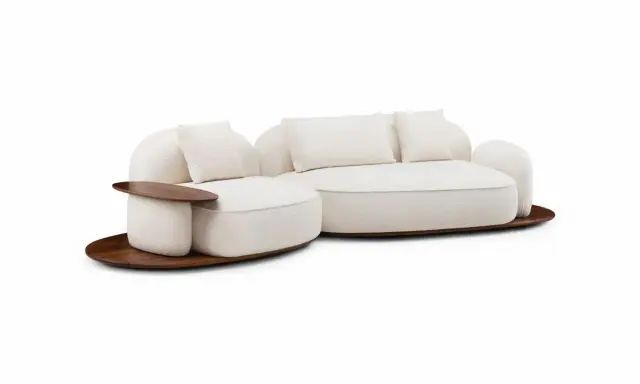 En mjuk, cremefärgad soffa med trädetaljer, designad av Luca Nichetto, står på en rund träplatta.