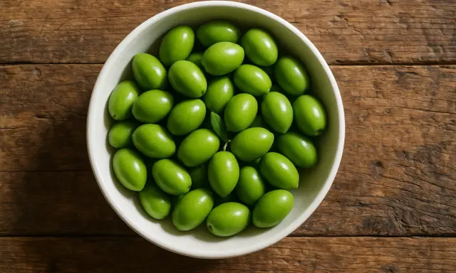 Un cuenco lleno de olivas verdes frescas, perfectas para disfrutar de sus beneficios.