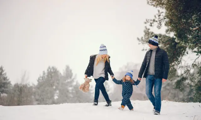 Famiglia felice in vacanze montagna bambini, camminano nella neve con cappelli coordinati.