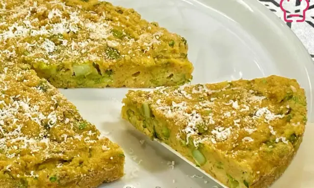 Una fetta di torta salata asparagi, dorata e cosparsa di parmigiano, pronta per essere gustata.