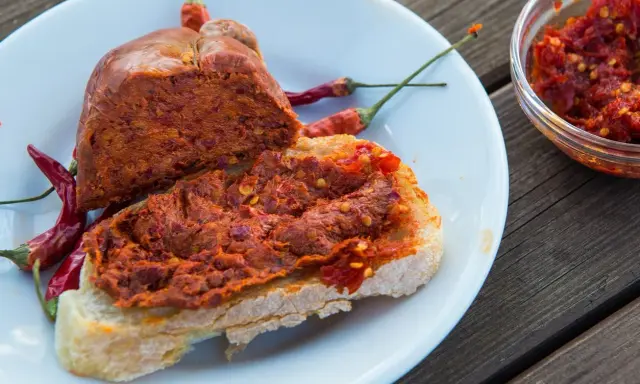 Fetta di pane con 'nduja e peperoncino, un assaggio di vero mangiare calabrese.