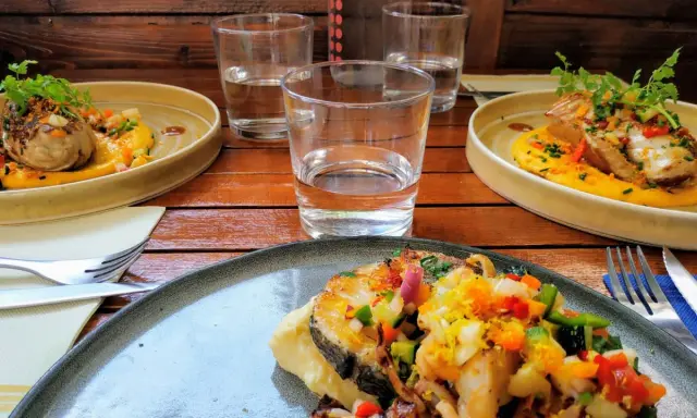 Trois assiettes de poisson grillé, purée de courge, légumes croquants et herbes fraîches. Une spécialité pyrénéenne à déguster.