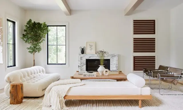 Salones blancos y madera: un sofá blanco texturizado, un diván de madera y un árbol interior crean un espacio acogedor.