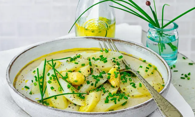 Ein Teller mit Spargel Salat, garniert mit Schnittlauch und einer leichten Sauce.